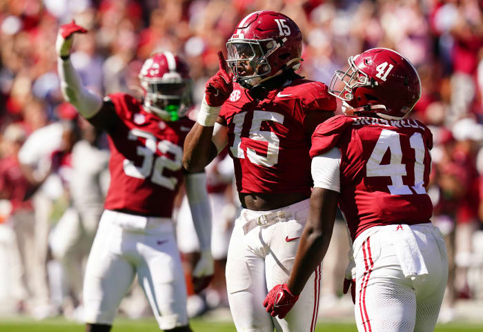Dallas Turner puts his finger up in front of his mouth in a shushing move as another player runs up to celebrate with him